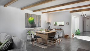 Ein modernes Wohnzimmer mit einem Holzesstisch, einem grauen Sofa und einer großen Kunstausstellung eines grünen Apfels.
