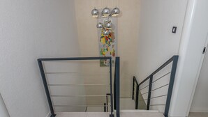 A modern staircase with metal railings and a decorative light fixture. - Lorena Crikvenica in Crikvenica (Crikvenica)