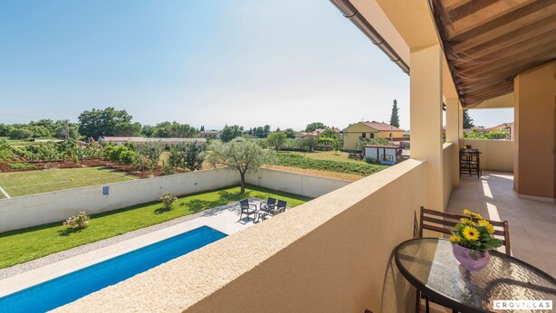 A balcony with a pool, outdoor seating, and a view of a garden and houses. - Dija in Jur i i With 3 Bedrooms and 3 Bathrooms (Svetvincenat)