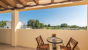 A balcony with two wooden chairs and a small table, a vase with flowers, and a clear view of the surrounding landscape. - Dija in Jur i i With 3 Bedrooms and 3 Bathrooms (Svetvincenat)
