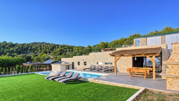A pool area with lounge chairs and a pergola, surrounded by stone walls and a view of a hillside. - Vita in Muter With 6 Bedrooms and 6 Bathrooms (Tisno)