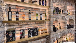 A wine cellar with shelves of various wine bottles and a brick wall. - Vita in Muter With 6 Bedrooms and 6 Bathrooms (Tisno)