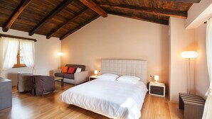 A bedroom with a large bed, a nightstand, a chair, and a lamp. - Poropati in Groznjan (Groznjan)