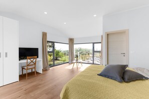 Ein modernes Schlafzimmer mit einem großen Bett, einem Schreibtisch und einem Fernseher.