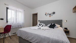 A hotel room with a bed, a desk, a chair, and a window with sheer curtains. - Alison Deluxe in Zupanici (Sveta Nedelja)