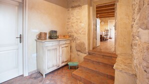 A stone-walled hallway with a wooden staircase leading to a dining area. - Gelci in Trget With 3 Bedrooms and 3 Bathrooms (Rasa)