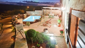 A rooftop pool area with a stone wall, potted plants, and outdoor furniture. - Gelci in Trget With 3 Bedrooms and 3 Bathrooms (Rasa)