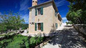A traditional stone building with green shutters, a chimney, and a stone wall. - Gelci in Trget With 3 Bedrooms and 3 Bathrooms (Rasa)