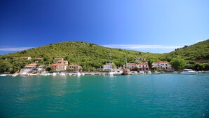 A coastal town with buildings on a hillside, boats docked at the harbor, and clear blue skies. - Gelci in Trget With 3 Bedrooms and 3 Bathrooms (Rasa)