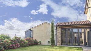 A residential property with a well-maintained lawn, a stone pathway, and a large glass door entrance. - Benvenuti in Motovun (Motovun)