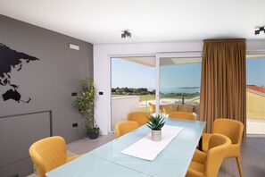 A modern conference room with a glass table, yellow chairs, a potted plant, and a large window with a view of the outdoors. - Tina Ocean View in Medulin (Medulin)