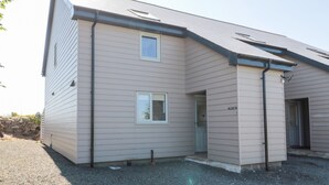 A two-story house with a sloped roof, a front porch, and a small attached garage.