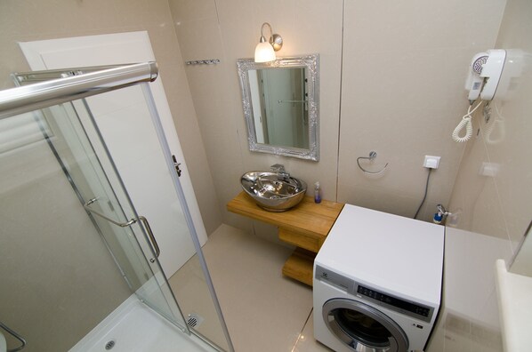 A bathroom with a glass shower enclosure, a sink with a silver basin, a mirror, and a wall-mounted hairdryer. - Kos in Murter With 11 Bedrooms and 6 Bathrooms (Murter-Kornati)
