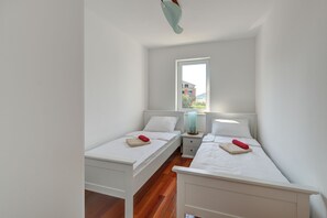 A bedroom with two single beds, a window, and a nightstand with a lamp. - Kos in Murter With 11 Bedrooms and 6 Bathrooms (Murter-Kornati)