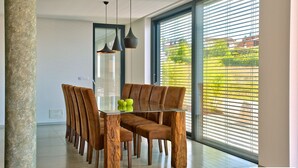 A dining area with a glass table, wooden chairs, and pendant lighting. - Aria in Vi Njan With 5 Bedrooms and 4 Bathrooms (Visnjan)
