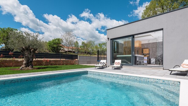 A modern house with a swimming pool, two lounge chairs, and a glass door leading to an interior space. - Alison Labin in Zupanici (Sveta Nedelja)