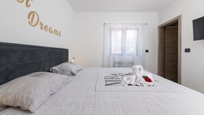 A neatly made bed with a white bedspread, two pillows, and a blanket with the text "MIR & YOU". - Alison Labin in Zupanici (Sveta Nedelja)