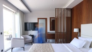 Une chambre d’hôtel moderne dotée d’un grand lit, d’une télévision, d’une cloison en bois et offrant une vue sur le balcon.