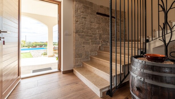 A staircase with stone walls and a wooden door leading to an outdoor area. - Lanca in Sveti Lovre (Sveti Lovrec)