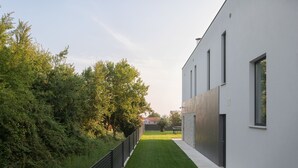 A modern building with a flat roof, a narrow pathway, and a well-maintained lawn. - Eden in Li Njan With 4 Bedrooms and 4 Bathrooms (Liznjan)