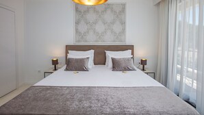 A hotel room with a large bed, two bedside lamps, a decorative wall piece, and sheer curtains. - Spuga in Brodarica With 4 Bedrooms and 4 Bathrooms (Sibenik)