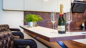 A modern kitchen with a bar area, featuring a bottle of Moët & Chandon Brut champagne, two glasses, and a potted plant. - Kamenica in Kras Krk (Dobrinj)