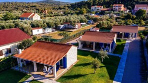 A residential area with houses featuring red-tiled roofs, a paved driveway, and a well-maintained lawn. - Duzac in Kraj With 2 Bedrooms and 2 Bathrooms (Pasman)