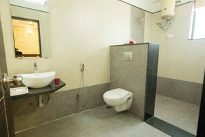 A bathroom with a sink, mirror, toilet, and shower.