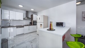 A modern kitchen with white cabinetry, a marble floor, a built-in oven, and a microwave on the countertop. - Frankovici in Pazin With 3 Bedrooms and 2 Bathrooms (Pazin)