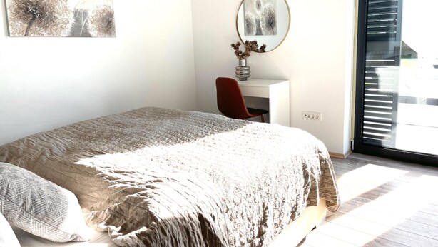 A bedroom with a bed, a desk, and a chair. There is a window with blinds, a wall-mounted mirror, and a painting on the wall. - Mala Oaza in Sveti Petar u umi (Sveti Petar u Sumi)