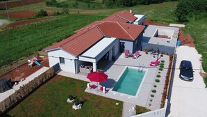 Une propriété résidentielle dotée d’une piscine, d’un espace extérieur aménagé et d’un vignoble.