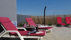 Ein Poolbereich mit Liegestühlen, einem Tisch mit Flaschen und einem Schild, das einen Swimmingpool kennzeichnet.
