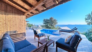 A wooden deck with a pool, lounge chairs, and a sofa. - Lux IV in Murter With 2 Bedrooms and 1 Bathrooms (Tisno)