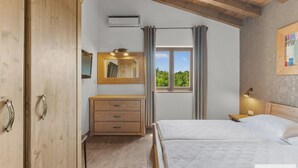 A bedroom with a wooden ceiling, a bed, a dresser, a mirror, and a window with curtains. - Dali in Svetvin Enat (Svetvincenat)