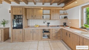 Eine Küche mit Holzausstattung, einem Backofen und einem Spülbecken.