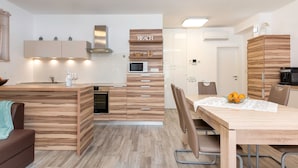 Eine moderne Küche mit Holzausstattung, einer Kochinsel und einem Essbereich mit Tisch und Stühlen.