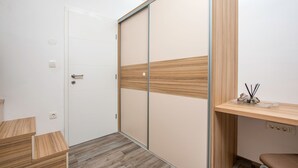 Ein modernes Zimmer mit einer Schiebetür, einem Holztisch, einem Stuhl und einem kleinen Tisch mit einem dekorativen Gegenstand.