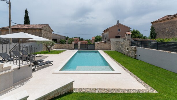 A rectangular swimming pool with a tiled deck, surrounded by a well-maintained lawn and stone walls. - Grande Brscici in Svetvincenat (Svetvincenat)