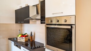 A modern kitchen with stainless steel appliances, a black countertop, and white cabinetry. - Luce in Zadar With 4 Bedrooms and 4 Bathrooms (Benkovac)