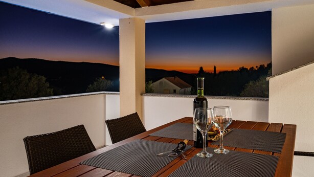 A terrace with a table set for two, featuring a bottle of wine and two glasses, overlooking a sunset view. - Luce in Zadar With 4 Bedrooms and 4 Bathrooms (Benkovac)