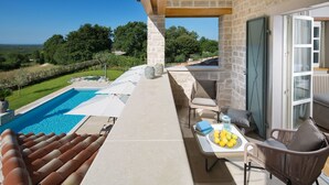 A balcony with a pool, outdoor furniture, and a table with fruits. - Nevia in Ladi i With 5 Bedrooms and 5 Bathrooms (Kanfanar)