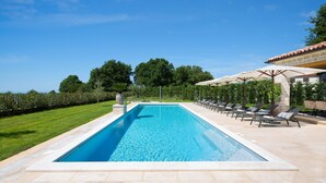 A rectangular swimming pool with clear blue water, surrounded by a tiled deck and lounge chairs. - Nevia in Ladi i With 5 Bedrooms and 5 Bathrooms (Kanfanar)