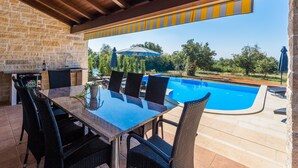 An outdoor patio with a pool, stone walls, and a covered seating area. - Laura An in Dekli i (Kastelir-Labinci)