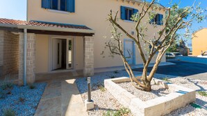 A two-story building with a beige facade, blue shutters, and a tiled roof. - Laura An in Dekli i (Kastelir-Labinci)