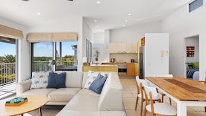 A modern apartment with a living area, dining space, and kitchen. - Unit 6 'Sea Breeze Villas' (Coolum beach)