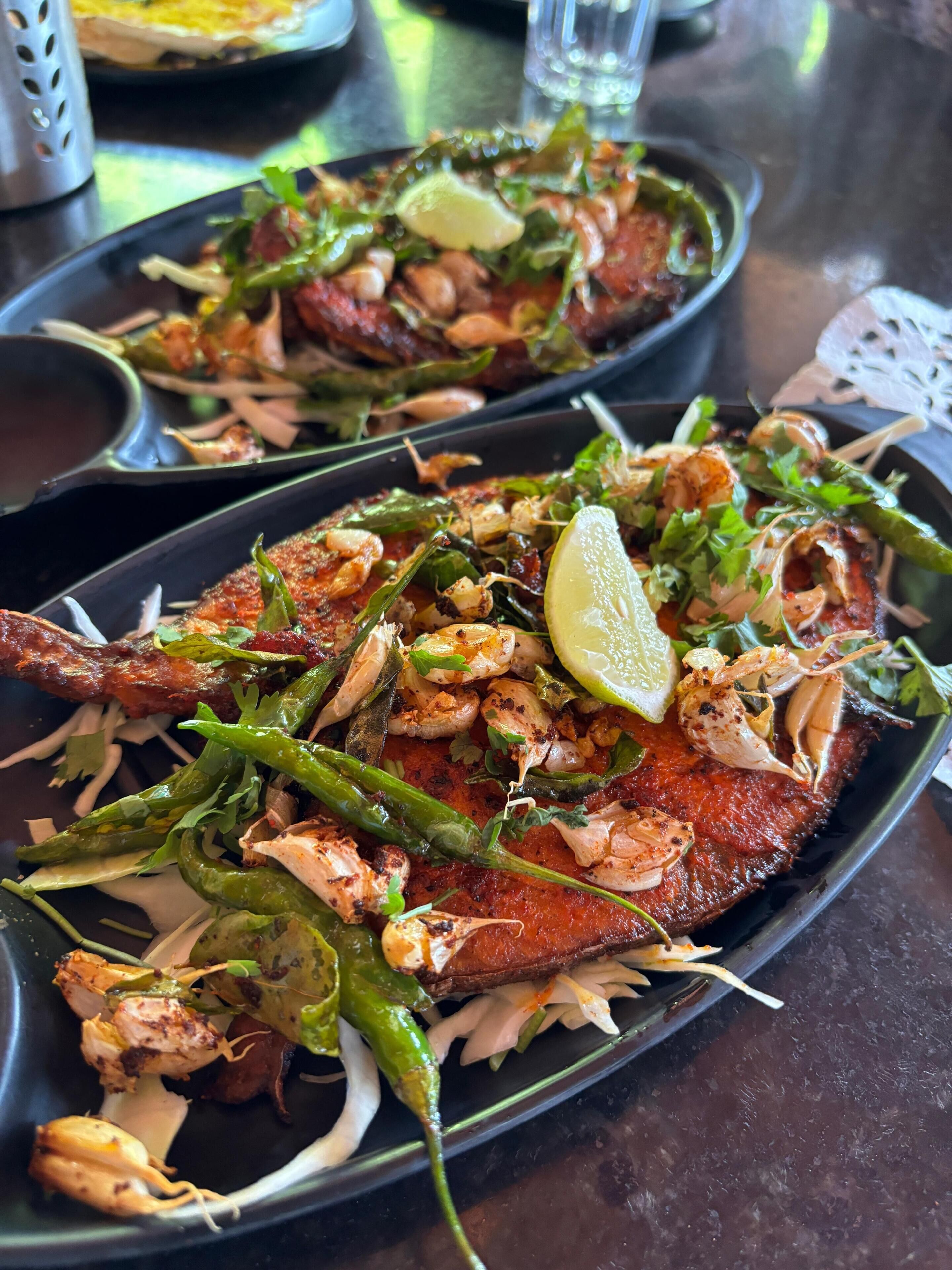 Plato con mariscos, camarones, pimientos verdes y una rodaja de lima.