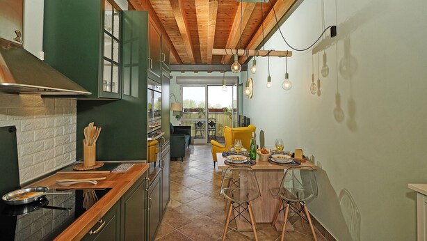 Une cuisine avec des meubles de rangement en bois, une cuisinière et un coin repas comprenant des chaises et une table.