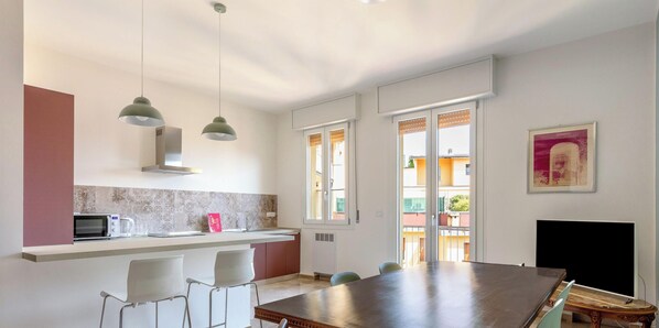 A modern kitchen with a dining area, a microwave, and a sink.