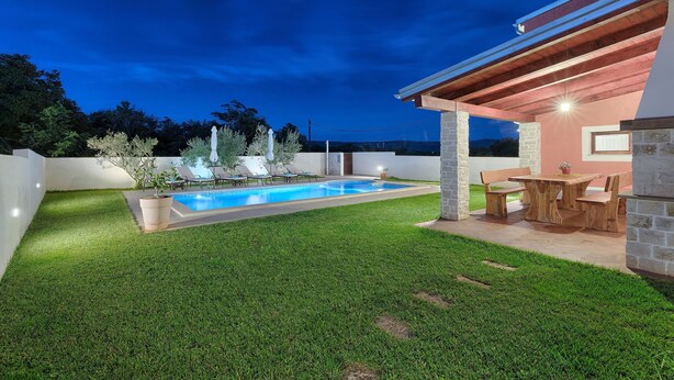 A backyard with a swimming pool, a wooden deck, and a covered seating area. - Prisedi in Rakalj With 4 Bedrooms and 3 Bathrooms (Marcana)