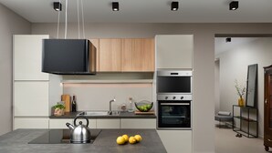 A modern kitchen with a central island, built-in oven, and a hanging light fixture. - Median in Vodnjan With 4 Bedrooms and 2 Bathrooms (Vodnjan)